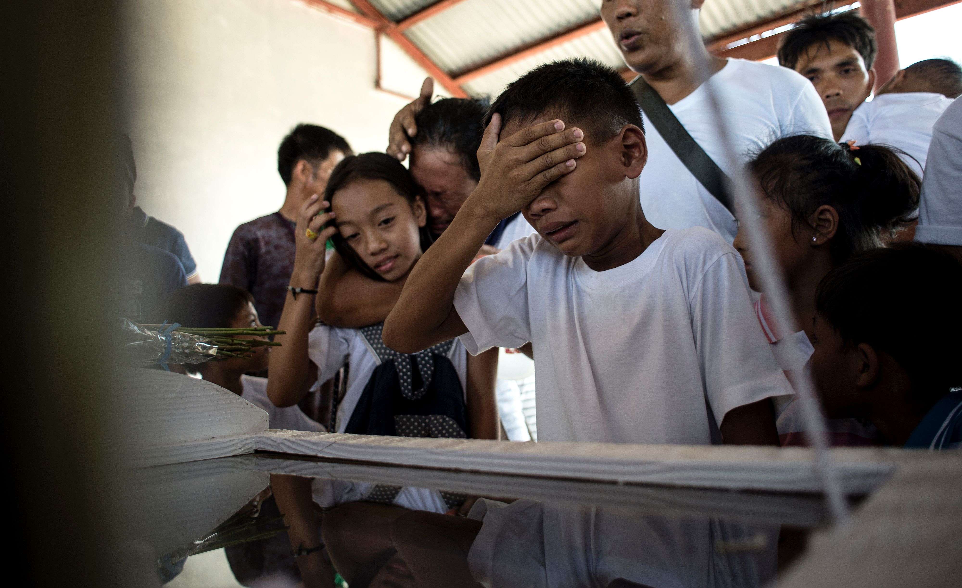 The son of an alleged drug user cries in front of his father’s casket before the burial in the north of Manila, on March 12. The father was gunned down by unidentified men. Photo: AFP