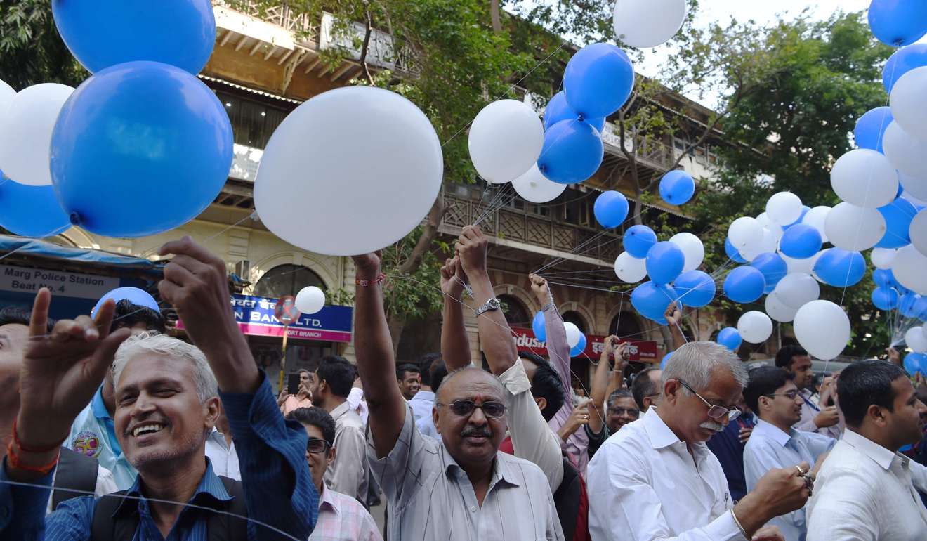 Workers holding balloons gather outside the Bombay Stock Exchange in Mumbai on Wednesday to celebrate the benchmark Sensex index crossing 30,000 points. Indian stock markets closed at record highs on April 24, buoyed by increased investor confidence in the domestic economy and in line with rises across Asia. Photo: AFP