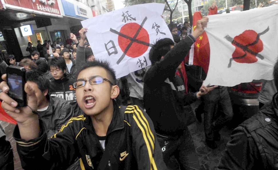 Protesters hold defaced Japanese flags during an anti-Japan demonstration in Lanzhou. Photo: Reuters