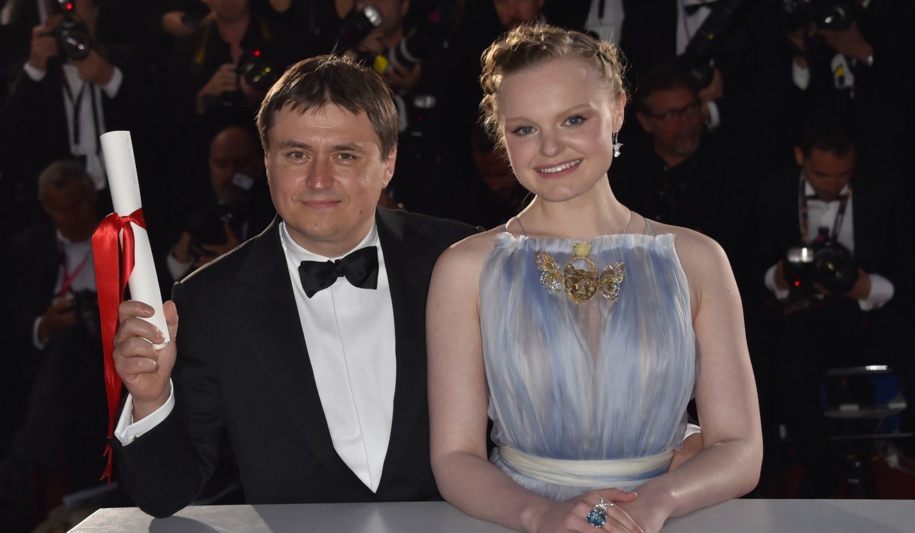 Cristian Mungiu celebrates with Maria-Victoria Dragus after being awarded the best director prize for Graduation. Photo: AFP