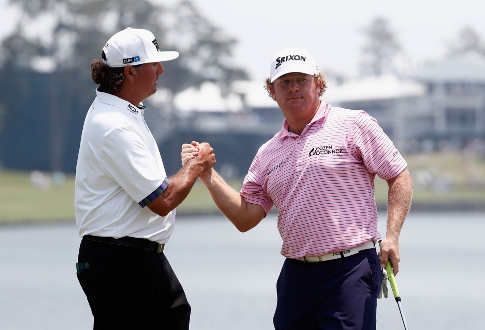 Pat Perez shakes hands with William McGirt during the first round of The Players Championship. Photo: AFP