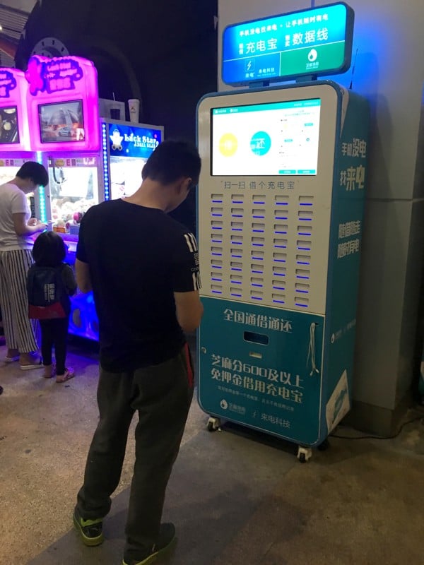 A customer uses a battery bank rental machine in Shenzhen. Photo: Yukin Pang