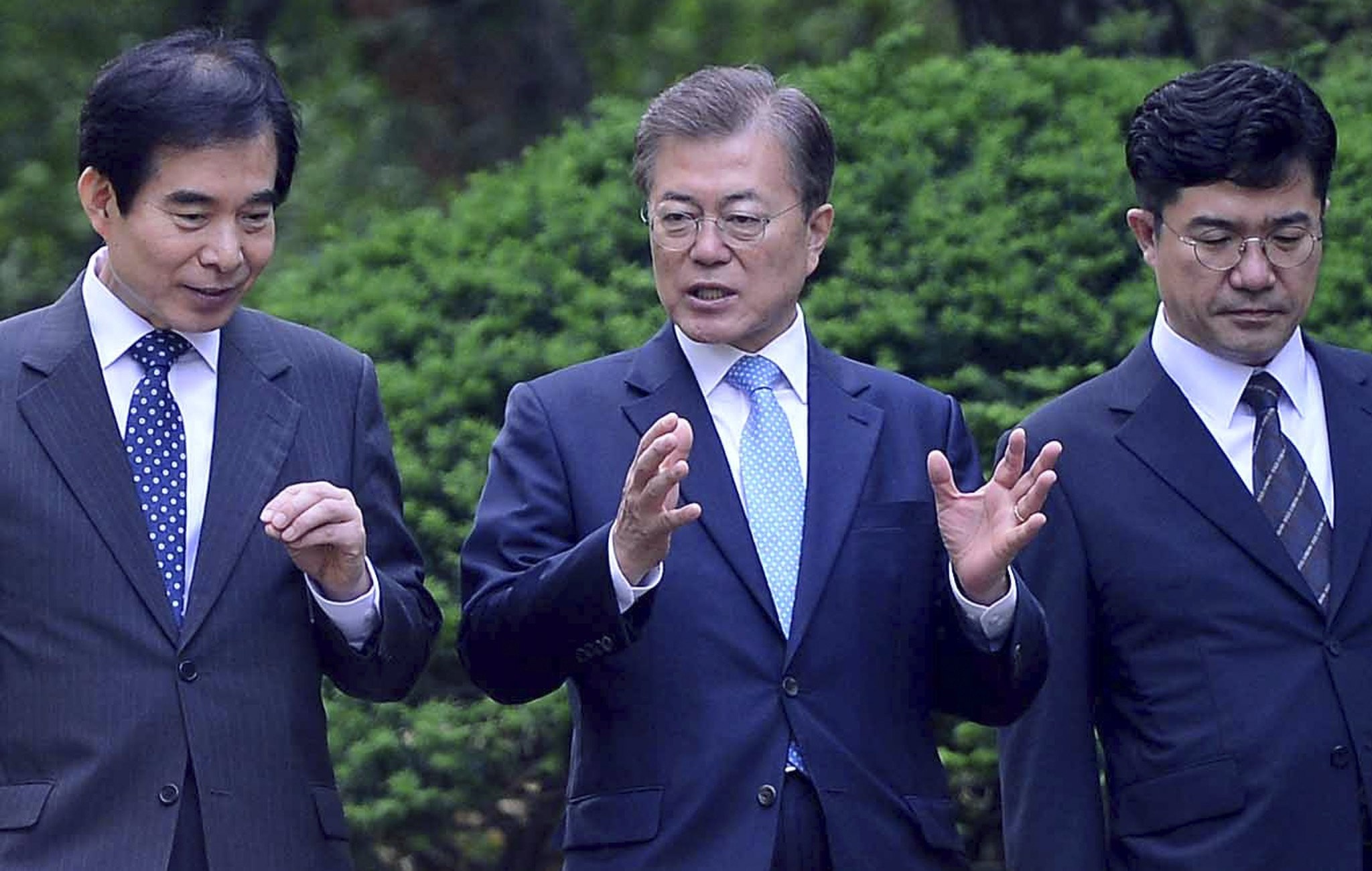 South Korean President Moon Jae-in speaks to his aides while walking to his office building at the Blue House presidential compound in Seoul. Photo: EPA