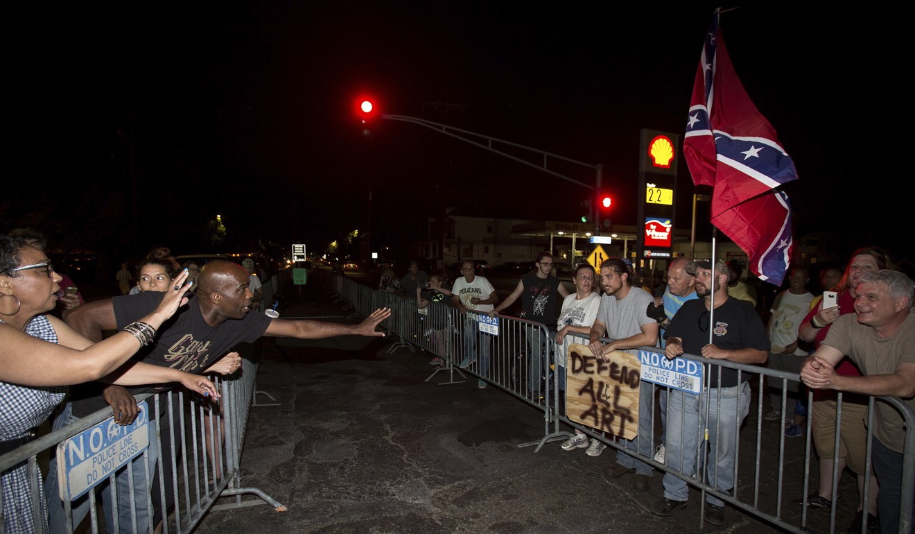 Anti-monument protesters Rose Hunter, left, and her son, Deshaun Washington make their case with pro-monument supporters, right, near the statue of Confederate Gen. P.G.T. Beauregard as the statue was prepared for removal from the entrance to City Park in New Orleans. Photo: AP