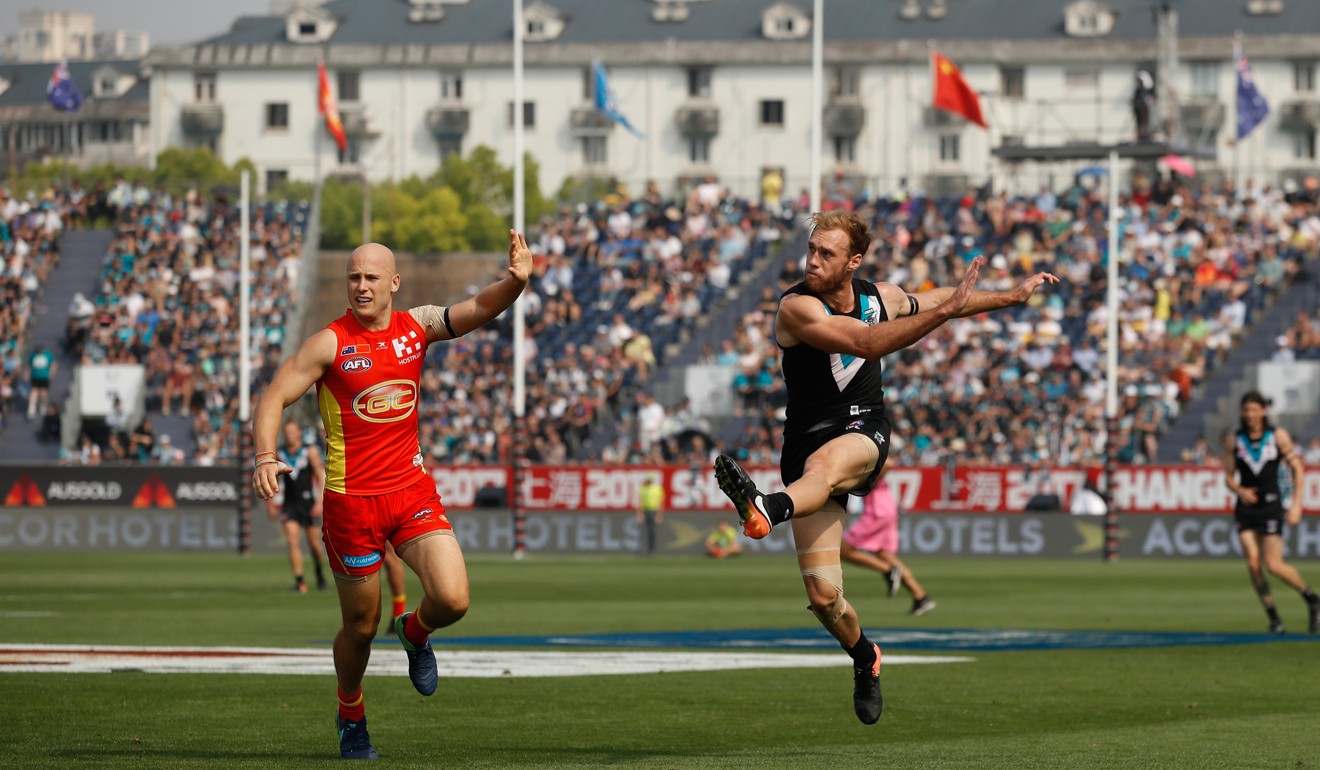 Port Adelaide’s Jack Hombsch launches a clearing kick at Jiangwan Stadium.