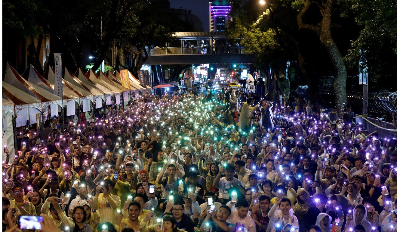 Supporters wave their mobile phone as torches in the colours of the rainbow during a rally celebrating the ruling in Taipei on Wednesday. Photo: Reuters