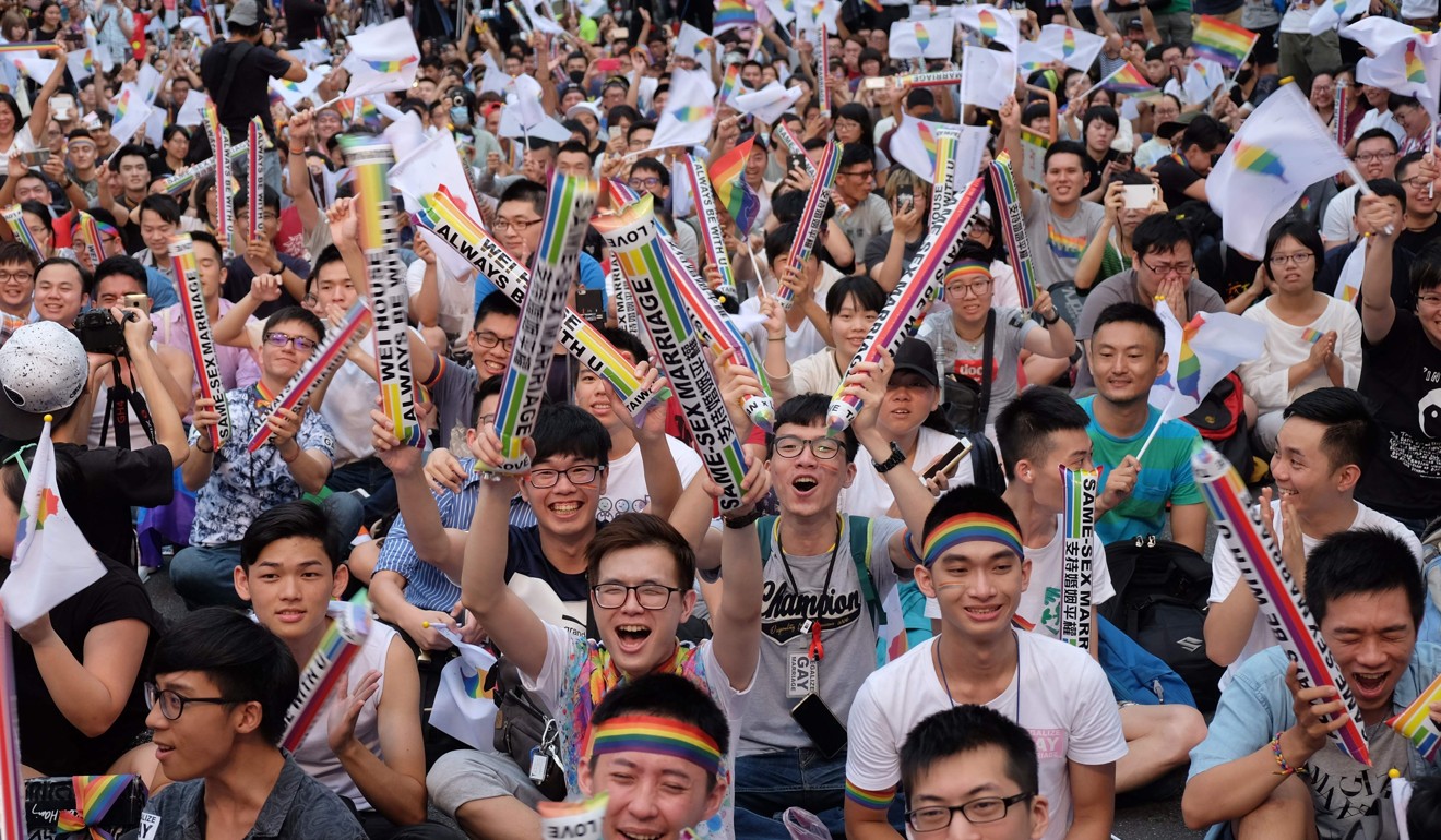 Gay rights activists celebrate outside parliament in Taipei on Wednesday after hearing the ruling. Photo: AFP