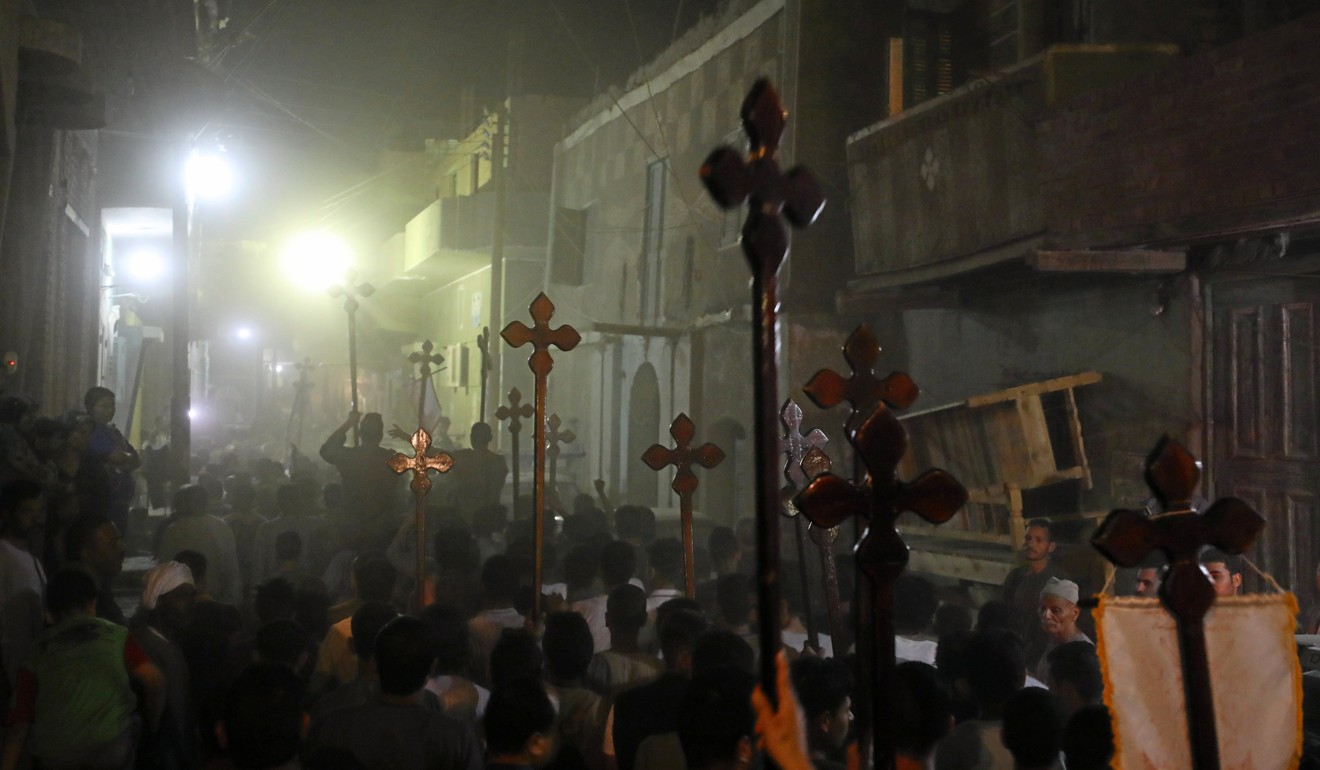 Mourners carry crosses and march after the funeral of the Coptic Christians. Photo: Reuters