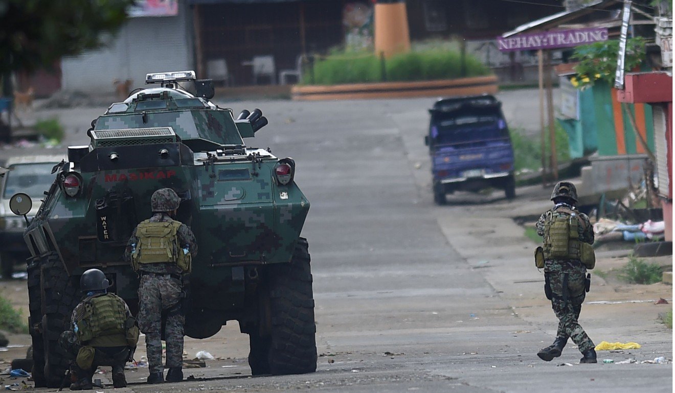 Police special forces attacking a Muslim militants’ hide out near the city hall in Marawi. Photo: AFP
