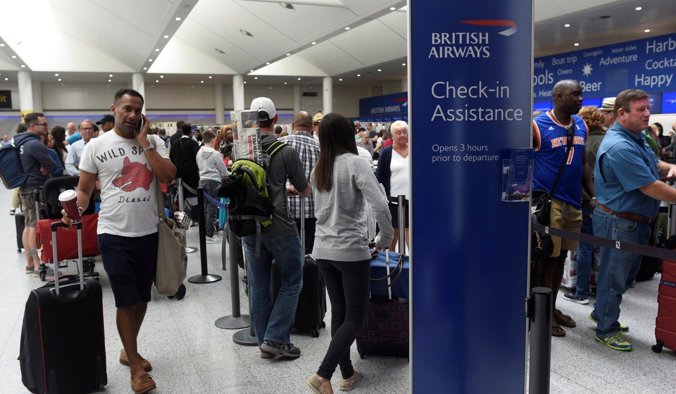 People queue with their luggage for the British Airways check-in desk at Gatwick Airport in southern England on Sunday. Photo: Reuters