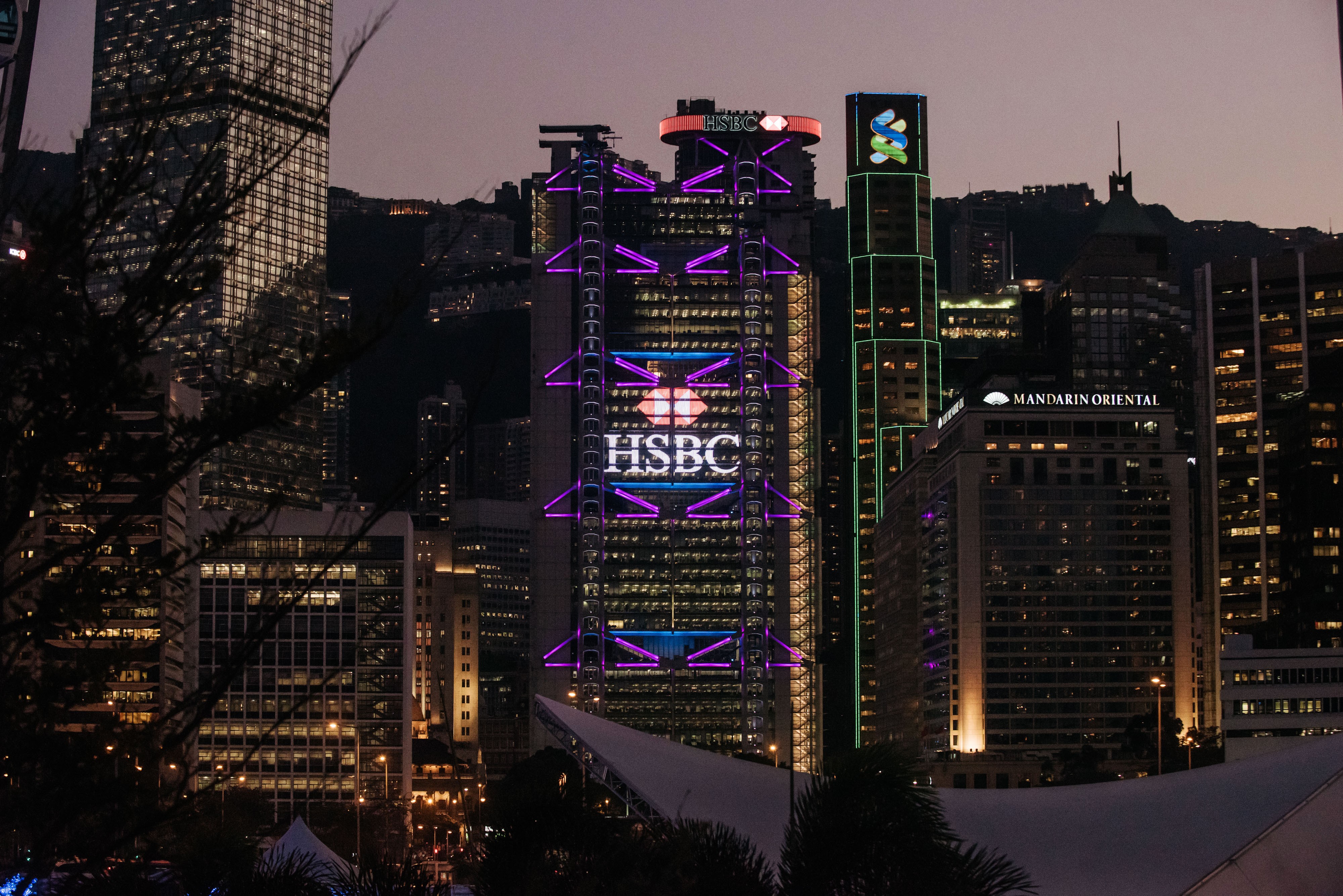 The HSBC and Standard Chartered buildings stand illuminated in Central, the commercial heart of Hong Kong, on February 13. Hong Kong’s financial services firms must step up self-policing if the city is to continue to grow and compete with other jurisdictions. Photo: Bloomberg