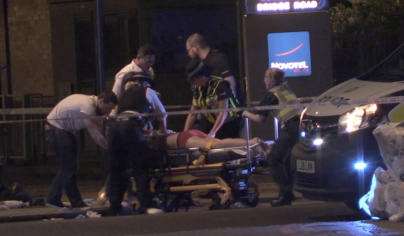 In this image made from PA Video footage, people receive medical attention in Thrale Street near London Bridge following the terrorist attack on Sunday. Photo: AP