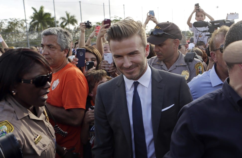 Beckham, surrounded by Miami-Dade police officers, fans and reporters, arrives at Kendall Soccer Park to visit and greet South Florida soccer fans and players in Miami. Photo: AP