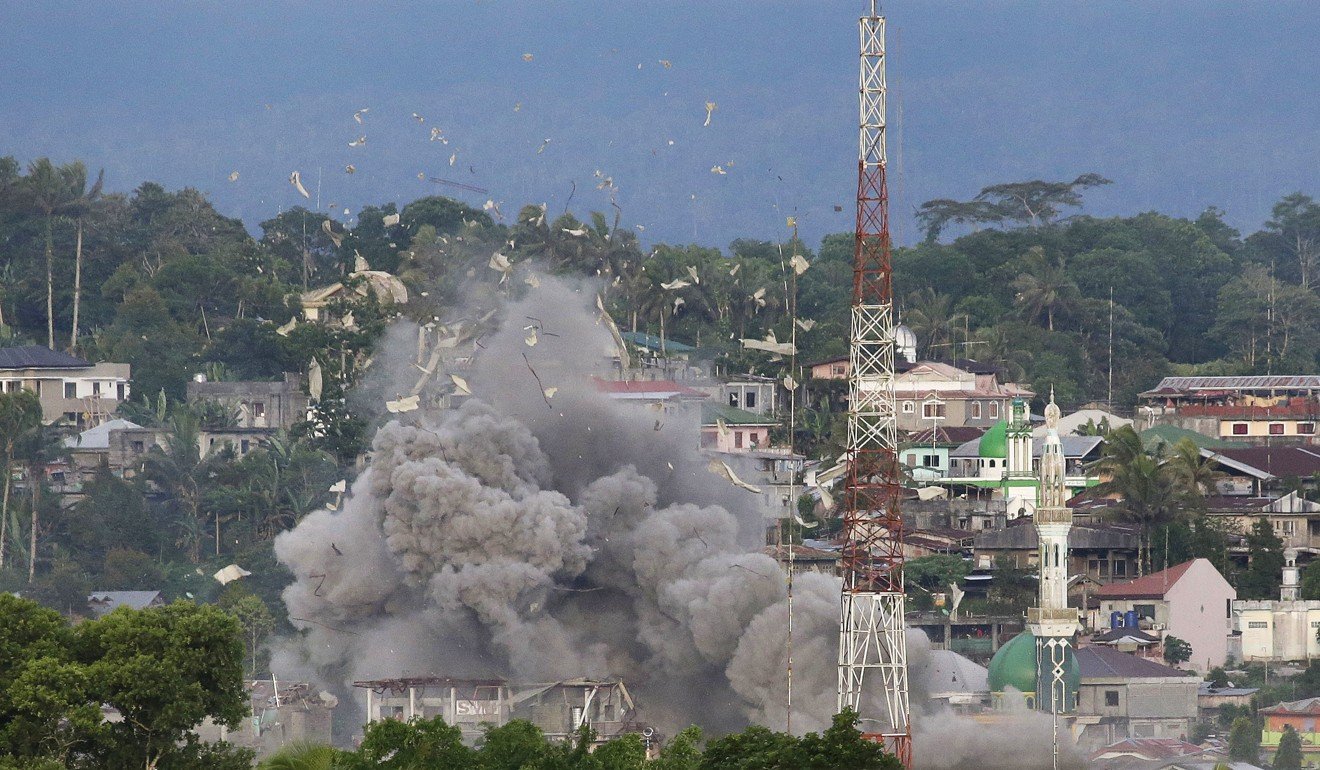 Debris flies in the air as Philippine Air Force planes bomb suspected locations of Muslim militants. Photo: AP