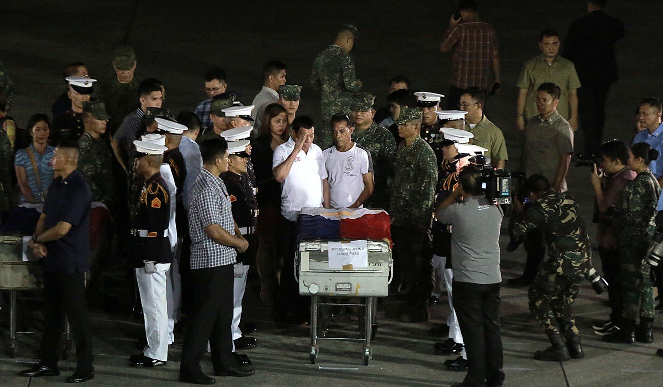 Philippine President Rodrigo Duterte salutes beside a relative of a soldier killed during the battle of Marawi. Photo: Xinhua