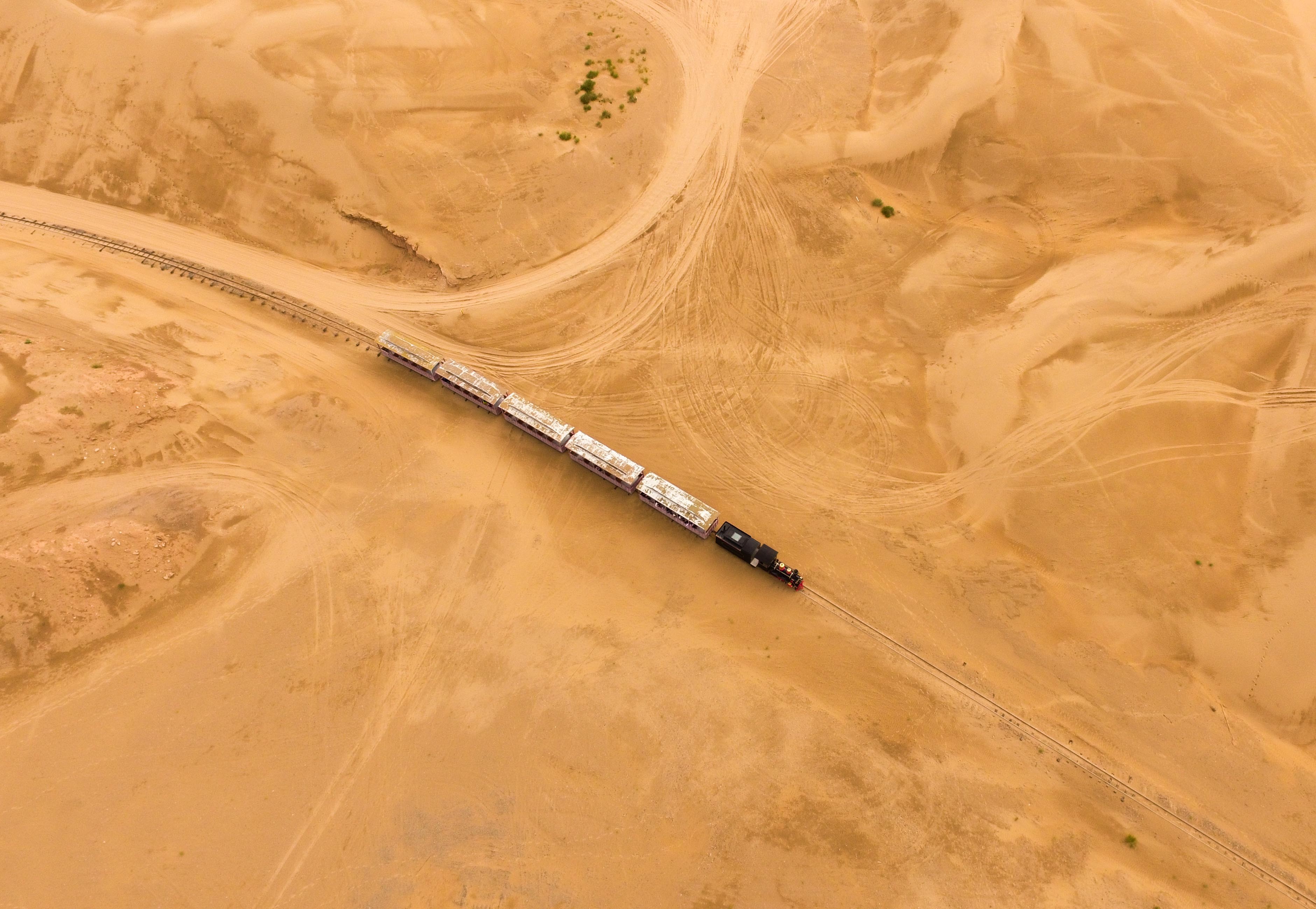A train runs through the Whistling Dune Bay in Dalad Qi in Ordos, in northern China's Inner Mongolia Autonomous Region. Located to the east of Kubuqi Desert, the Whistling Dune Bay was developed as a tourist destination since 1984. After years of improvement, it became a landmark for tourism industry of the Inner Mongolia Autonomous Region. Photo: Xinhua