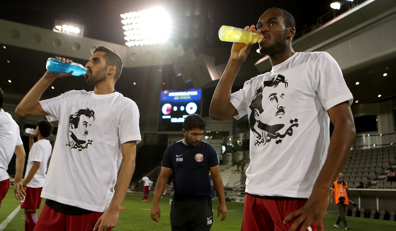 Qatar players Hasan Al-Haidous (left) and Abdulkarim Hasan wear T-shirts bearing portraits of Emir Sheikh Tamim bin Hamad Al-Thani, in support the Qatari leader. Photo: AFP