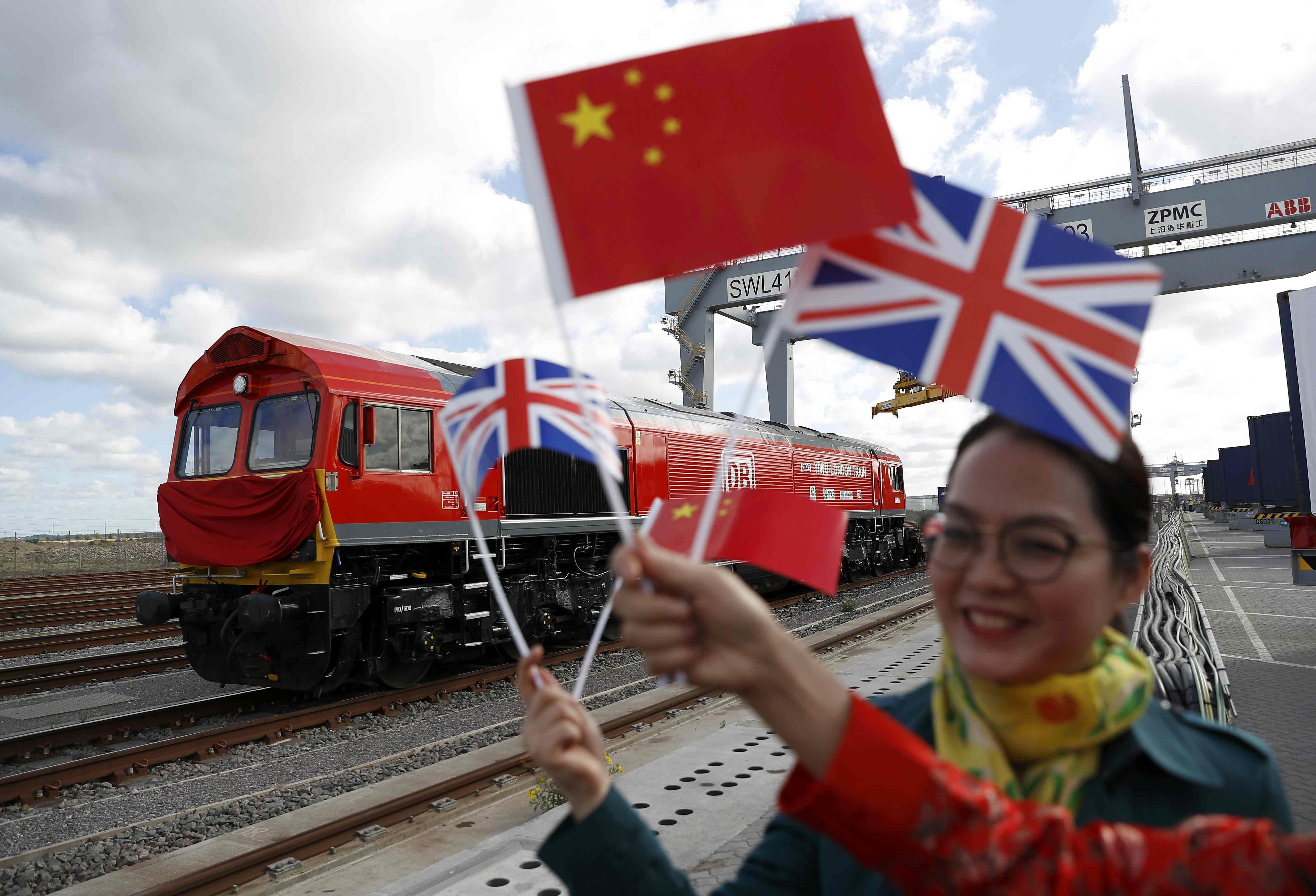 A Chinese woman waves flags at the official ceremony to mark the departure of the first UK to China export train, laden with containers of British goods, from the DP World London Gateway, Stanford-le-Hope, Britain in April. Photo: Reuters