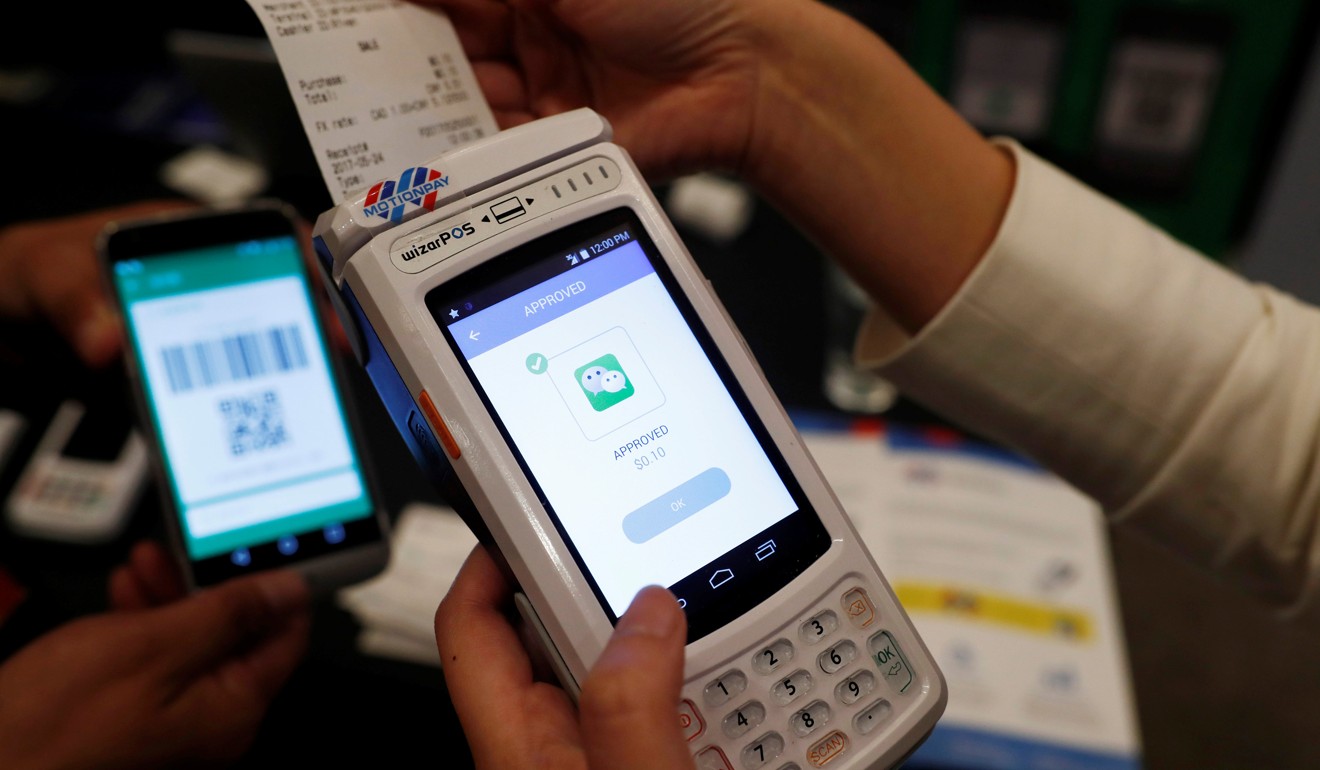 People demonstrate a high security digital unit built by Motion Pay that allows customers to pay in Chinese yuan using Chinese online money payment services WeChat Pay and Alipay. Photo: Reuters