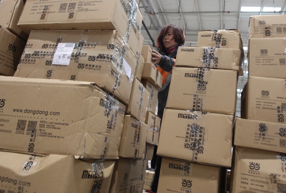 A worker gets lost behind a mass of packages at a delivery centre in mainland China. Photo: Simon Song