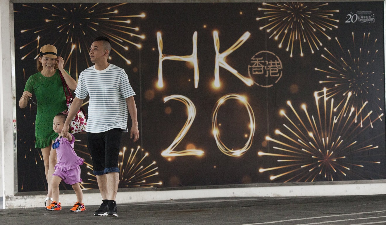 A young family walk past a poster promoting the 20th anniversary of the Hong Kong handover. “One country, two systems” will continue after 2047. Its meaning will be defined by Beijing, and the autonomy allowed will be more limited. But China will not want to see Hong Kong fade under Chinese sovereignty. Photo: EPA