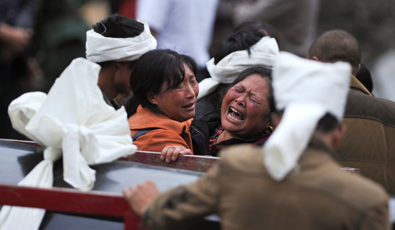 Women react as the body of a loved one is removed from the disaster site. Photo: Reuters