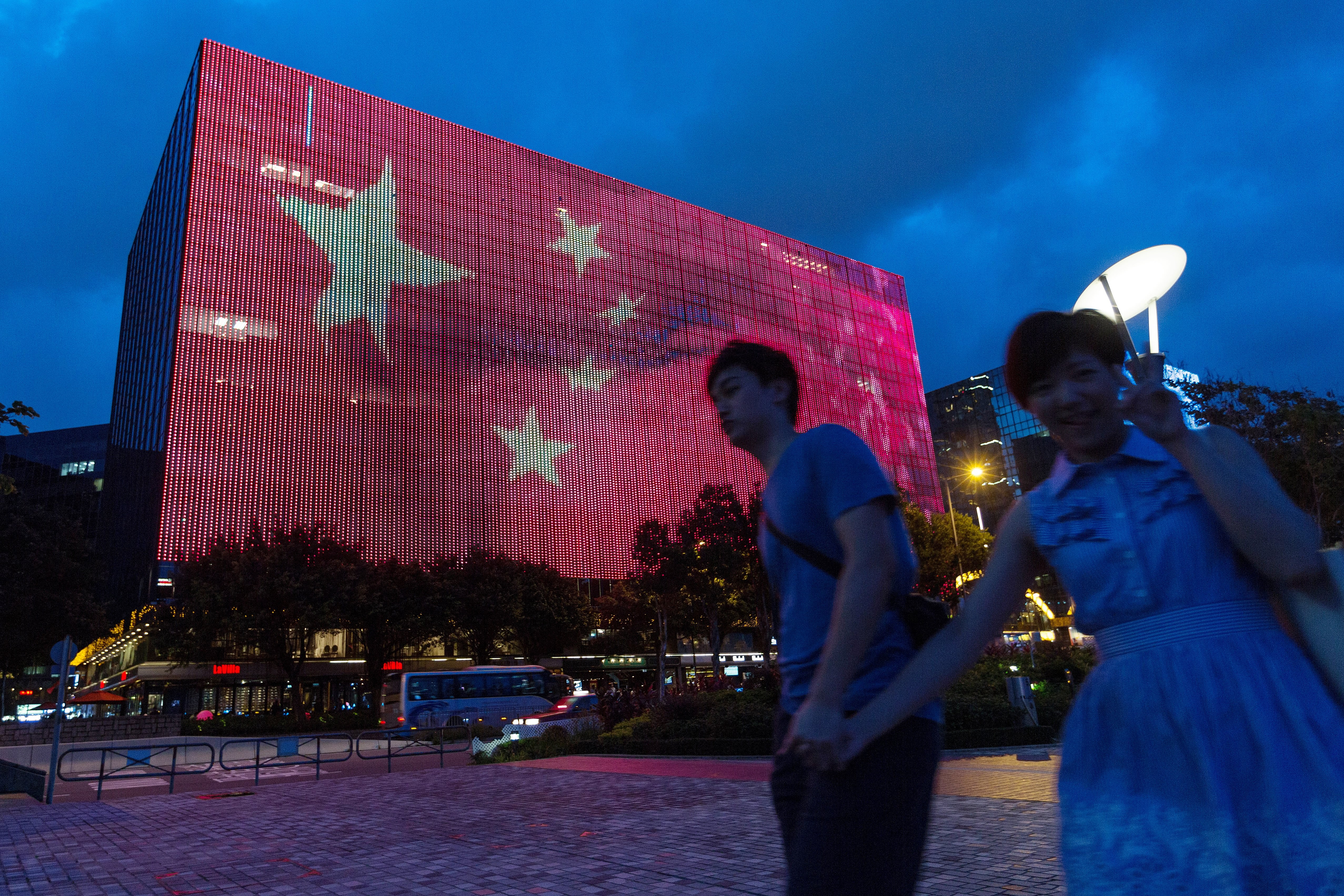 A couple walk past an image of the Chinese flag being projected on a building in Tsim Sha Tsui, ahead of the 20th anniversary of Hong Kong’s return to Chinese rule. China is a unitary nation, and the central government is responsible for the governance of its regions, for better and for worse. Photo: EPA