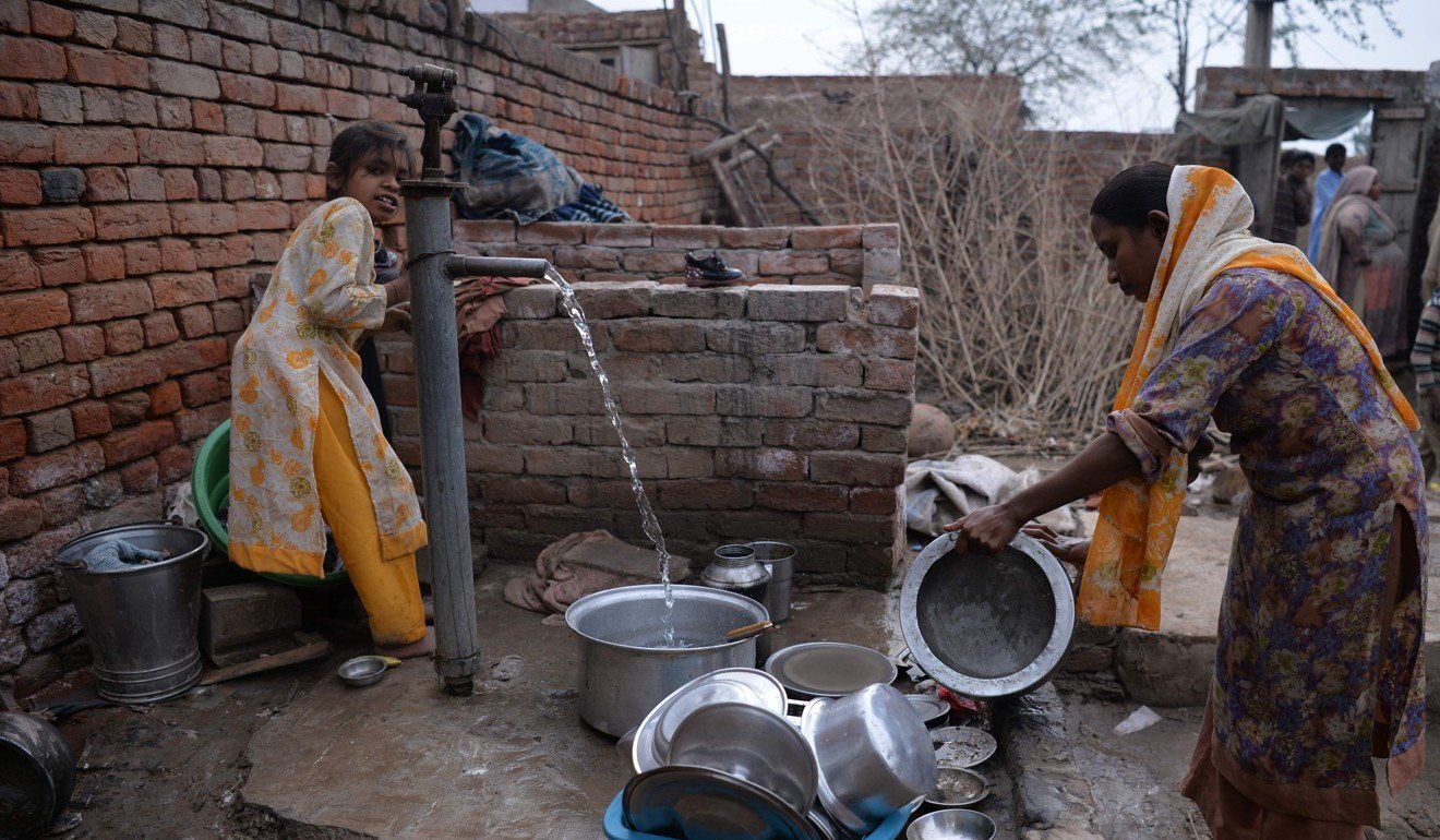 Bushra Bibi (right) who sold one of her kidneys, cleans dishes with her daughter at their home in Bhalwal in Sargodha District, Punjab province. Photo: AFP
