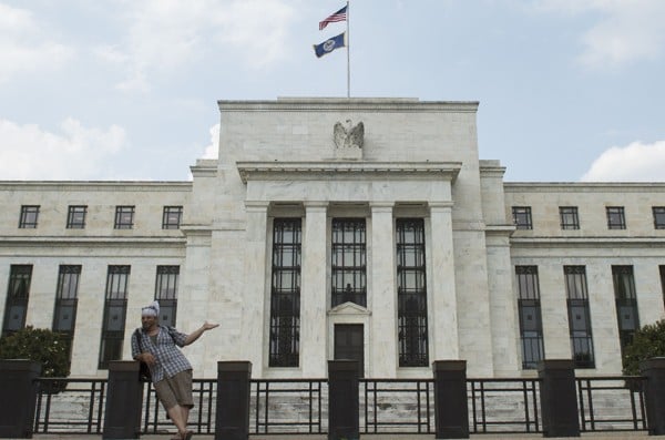 A tourist posing for a photo in front of the Federal Reserve in Washington, DC. Photo AFP