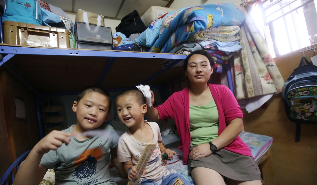 He Shuijin with her two sons inside their rooftop shack in Sham Shui Po. Photo: David Wong