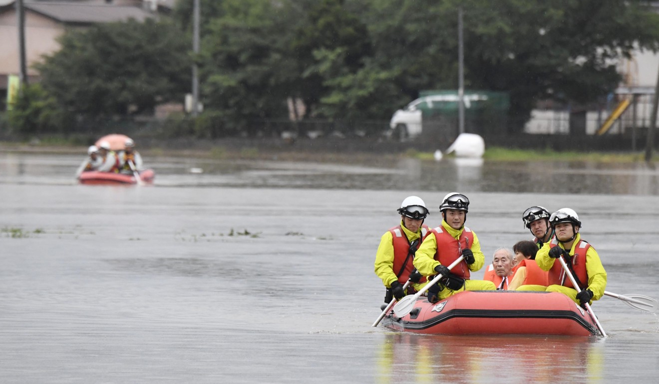 Stranded residents are rescued by boat in Asakura. Photo: Kyodo