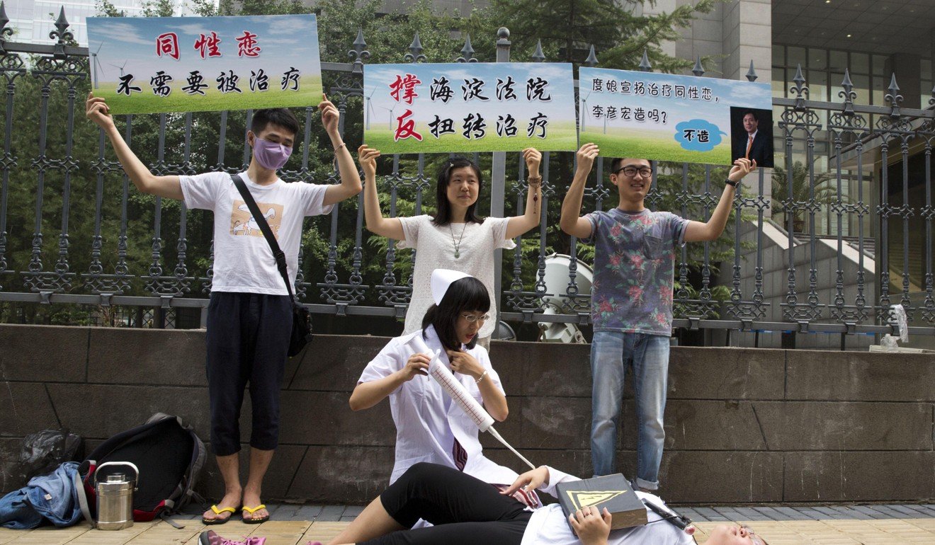 Gay rights campaigners act out electric shock treatment to protest outside a court in Beijing hearing a case involving so-called conversion therapy in July, 2014. Photo: AP