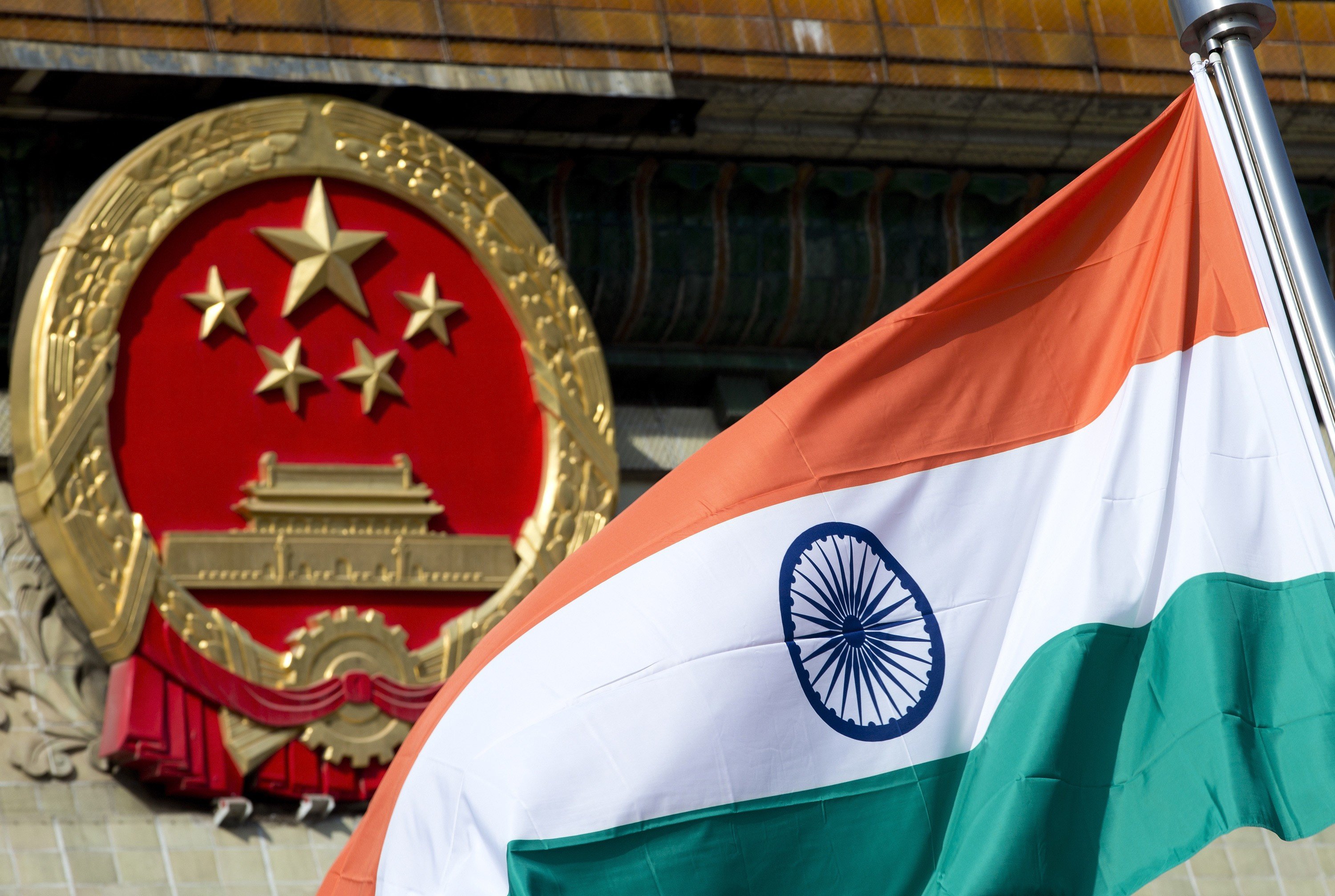 An Indian national flag is flown next to the Chinese national emblem outside the Great Hall of the People in Beijing in this 2013 file photo. Photo: Associated Press