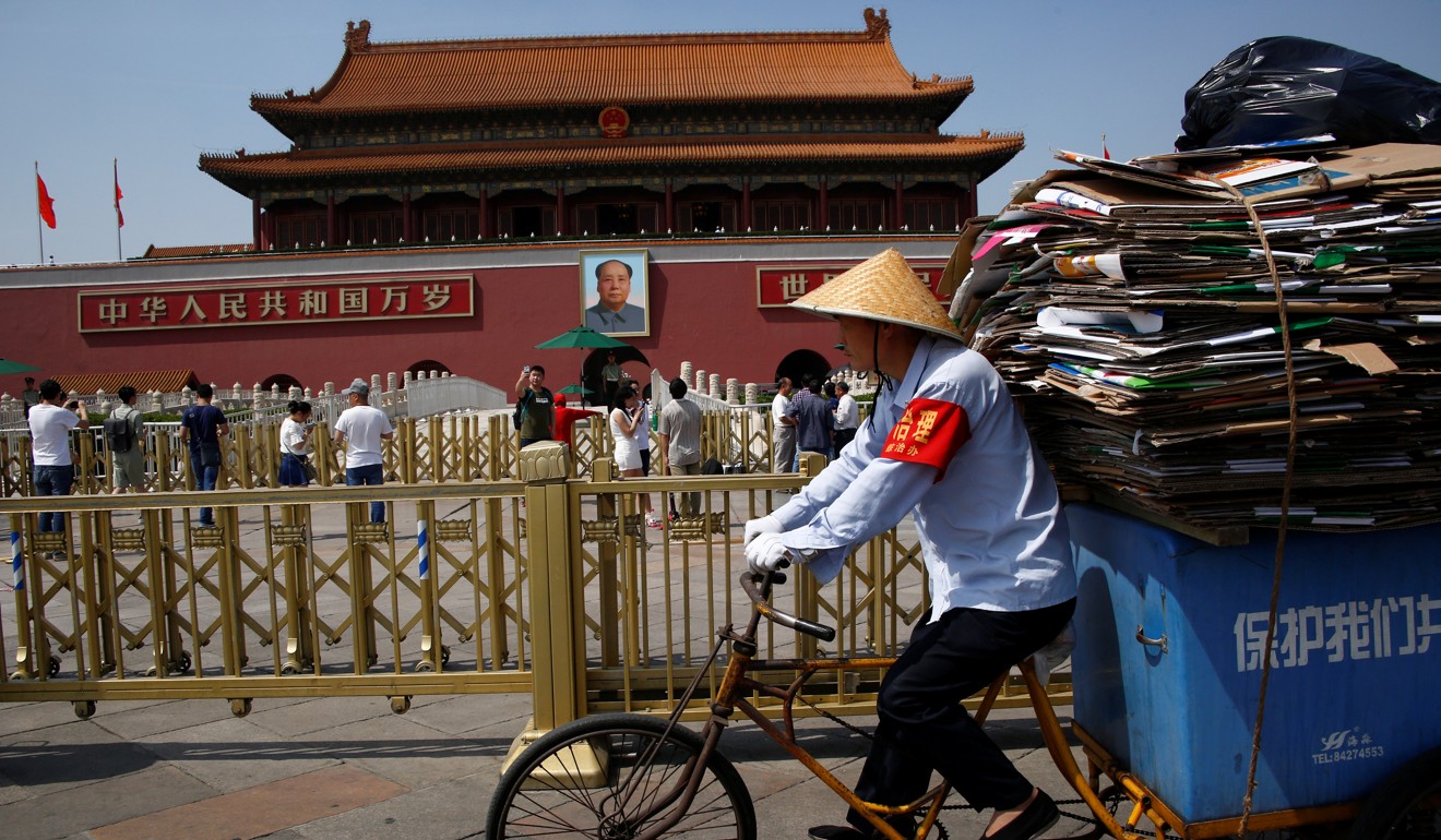 A man rides a tricycle carrying cardboard in Tiananmen Square in Beijing. Photo: Reuters