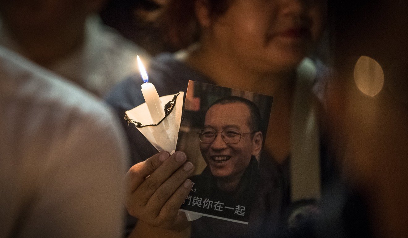 A woman holds a portrait of Liu Xiaobo during a candlelight vigil in Hong Kong on June 29. Photo: EPA