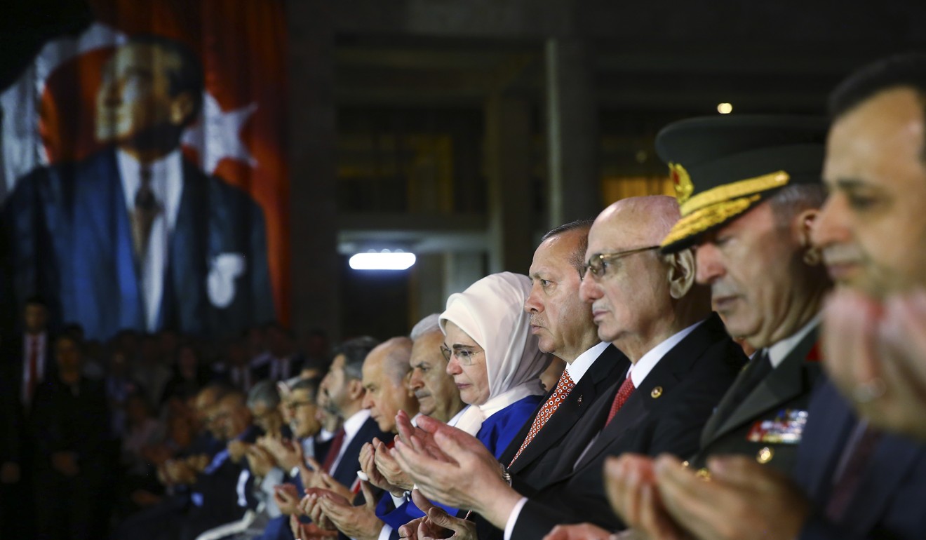 Erdogan (right of centre) prays during a ceremony at Turkey's parliament to commemorate the anniversary. Photo: AP