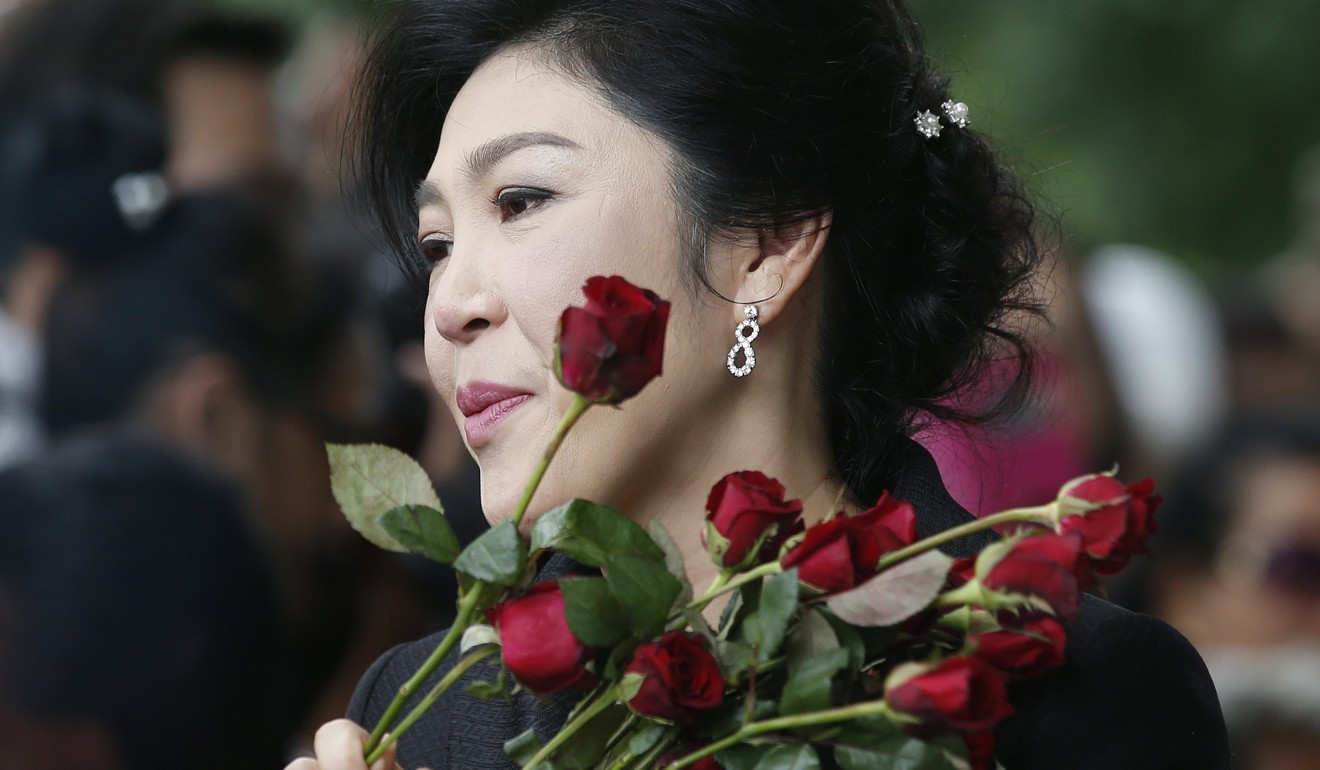 Former Thai Prime Minister Yingluck Shinawatra greets supporters as she arrives for her trial on the last round on criminal charges stemming from her government's rice price subsidy scheme. Photo: EPA