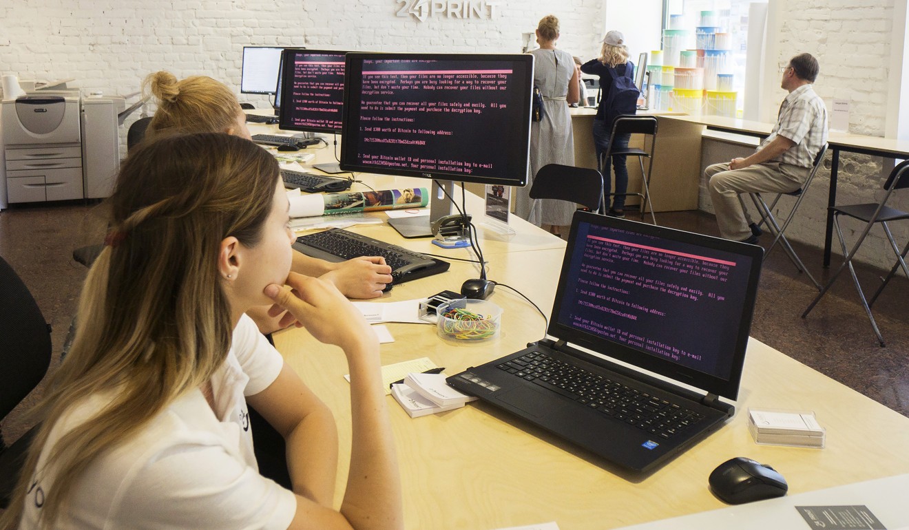 Employees of a retail store read a ransomware demand for the payment of US$300 worth of bitcoin on company computers infected by the “Petya” software virus, in Kiev, Ukraine, on June 28. Photo: Bloomberg