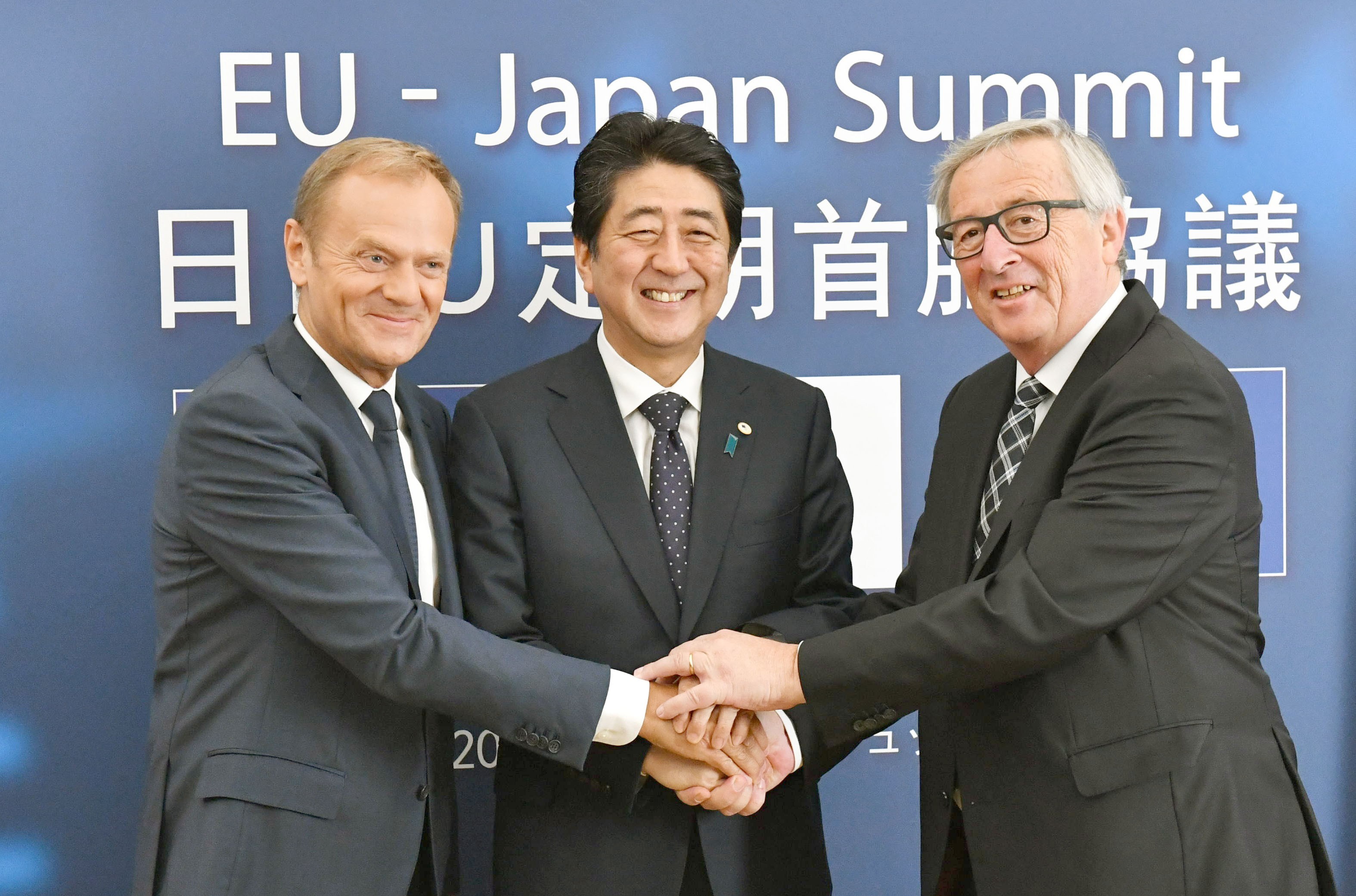 From left, European Council President Donald Tusk, Japanese Prime Minister Shinzo Abe and European Commission President Jean-Claude Junker shake hands in Brussels. Photo: Kyodo
