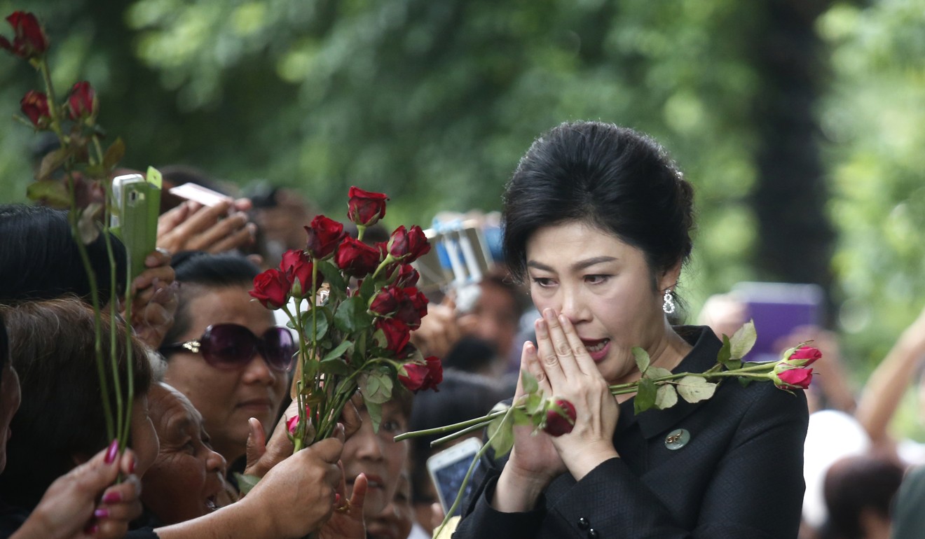 Former Thailand's Prime Minister Yingluck Shinawatra receives flower from her supporters during her arrival at the Supreme Court on July 21. Photo: AP