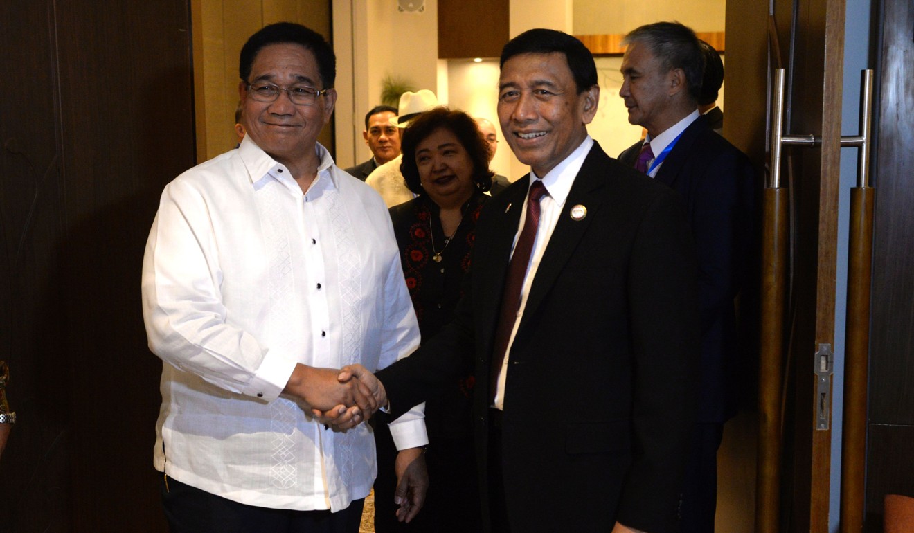Wiranto shaking hands with Philippines national defence adviser Hermogenes Esperon. Photo: AFP