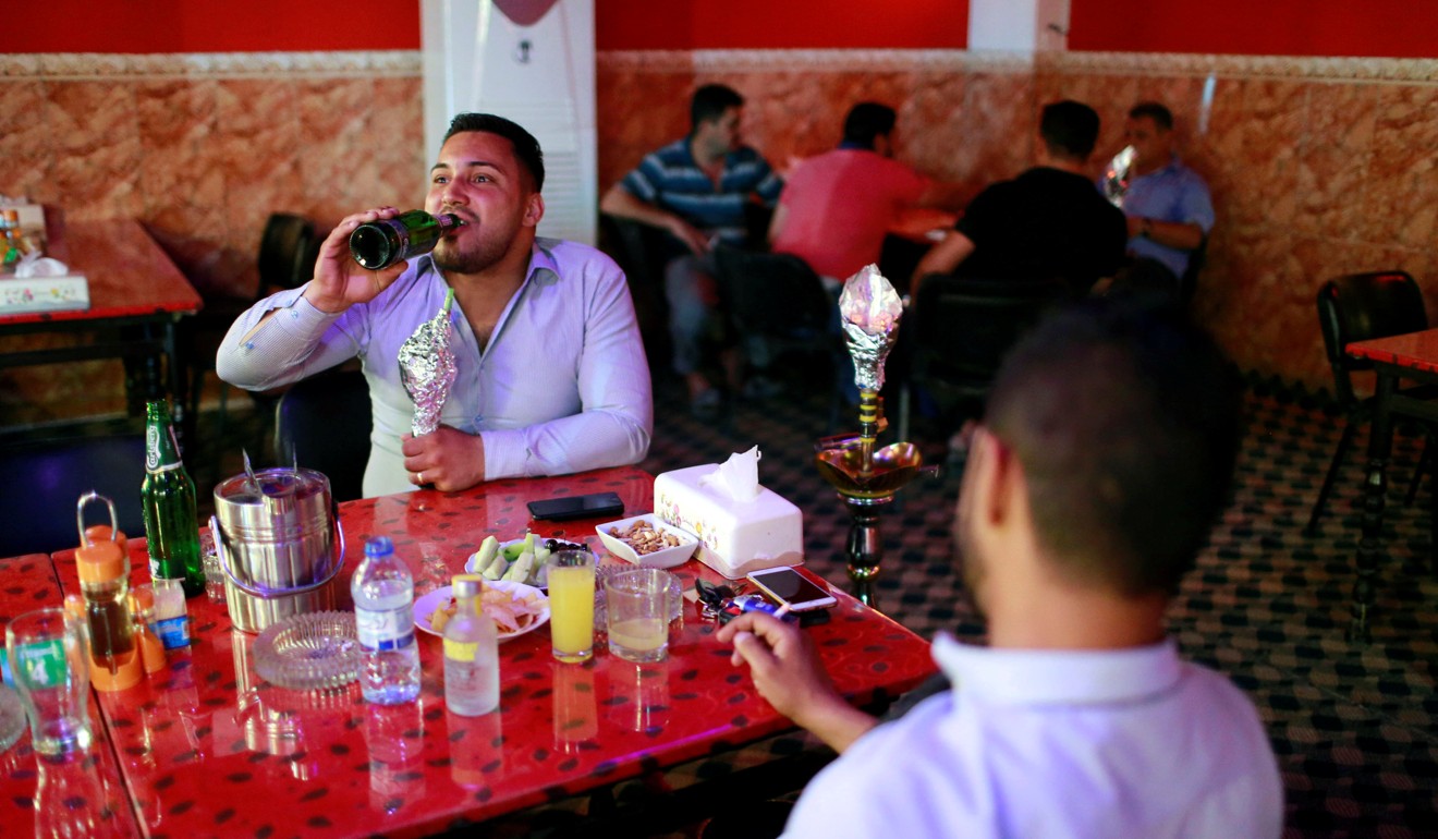 People drink at a bar in the town of Qaraqosh, south of Mosul. Photo: Reuters