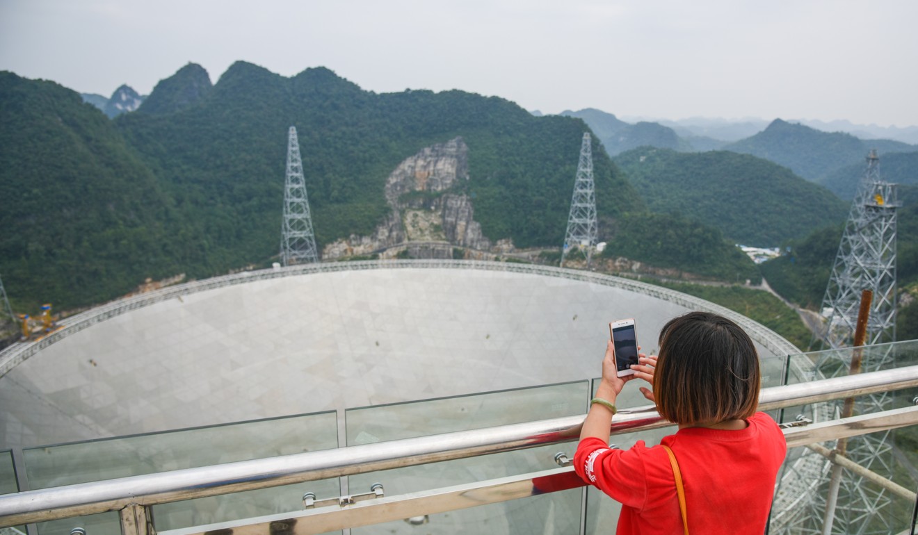 A visitor takes a photograph of the Fast telescope in Guizhou province. Picture: Xinhua