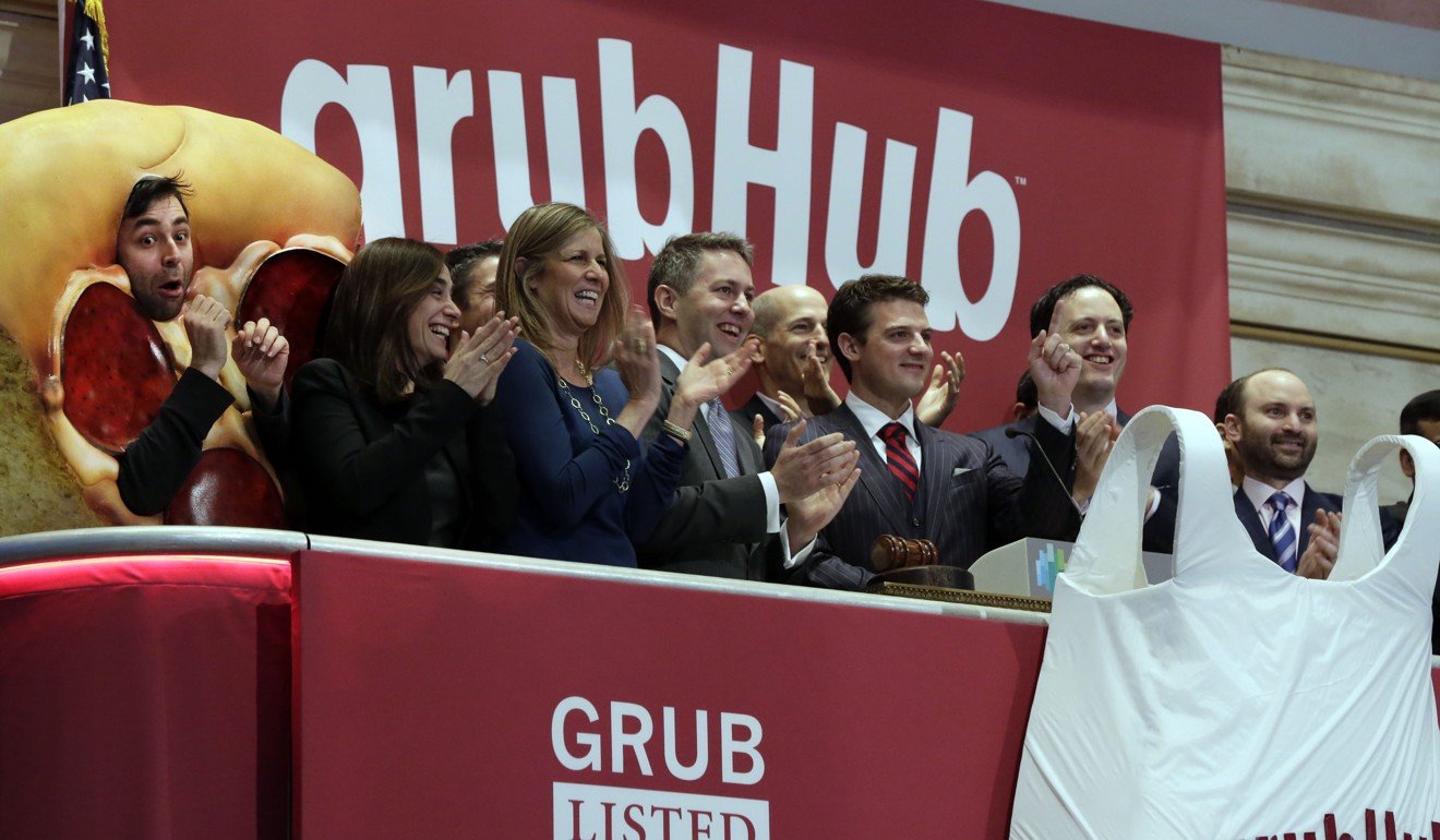 In this 2014 file photo, GrubHub CEO Matthew Maloney, third from right, is applauded as he rings the New York Stock Exchange opening bell. Grubhub plans to gobble up Yelp's Eat24 business. Photo: AP