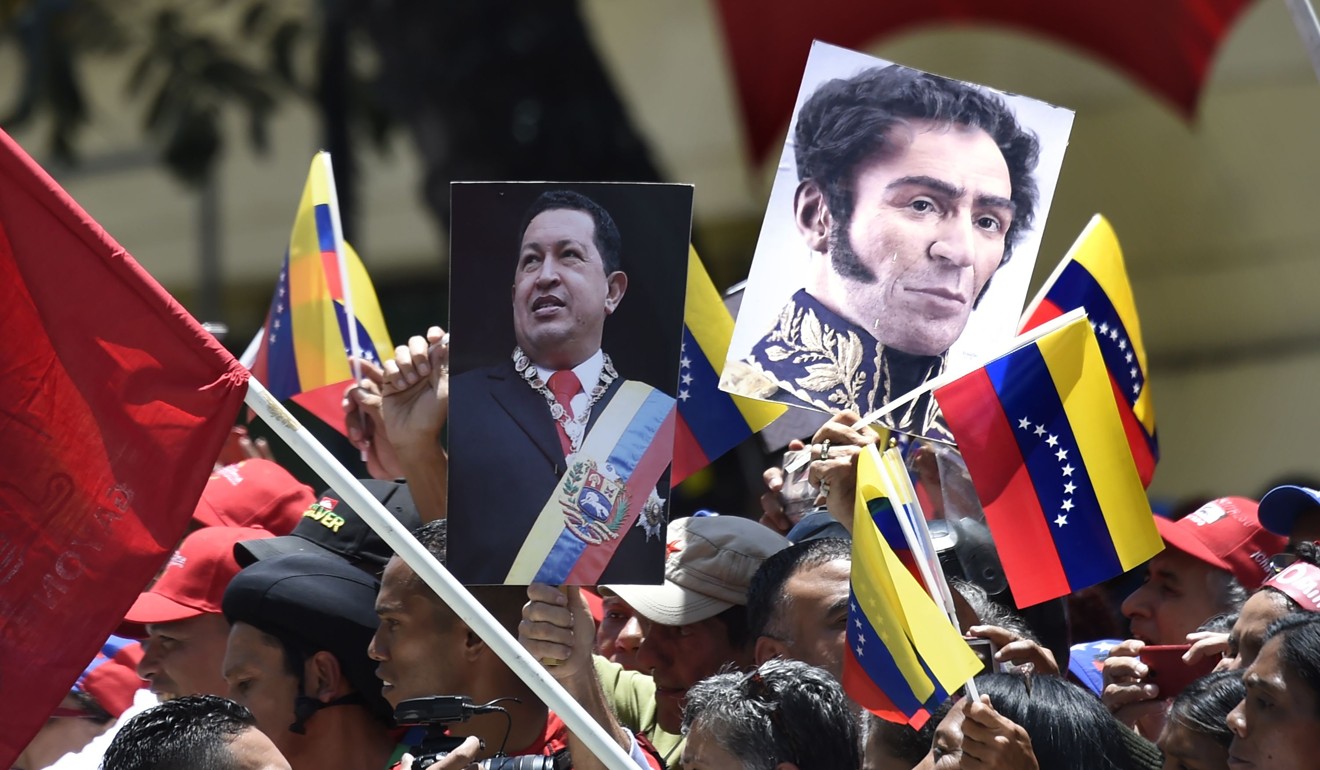Government supporters carry images of late Venezuelan President Hugo Chavez and Venezuelan liberator Simon Bolivar. Photo: AFP