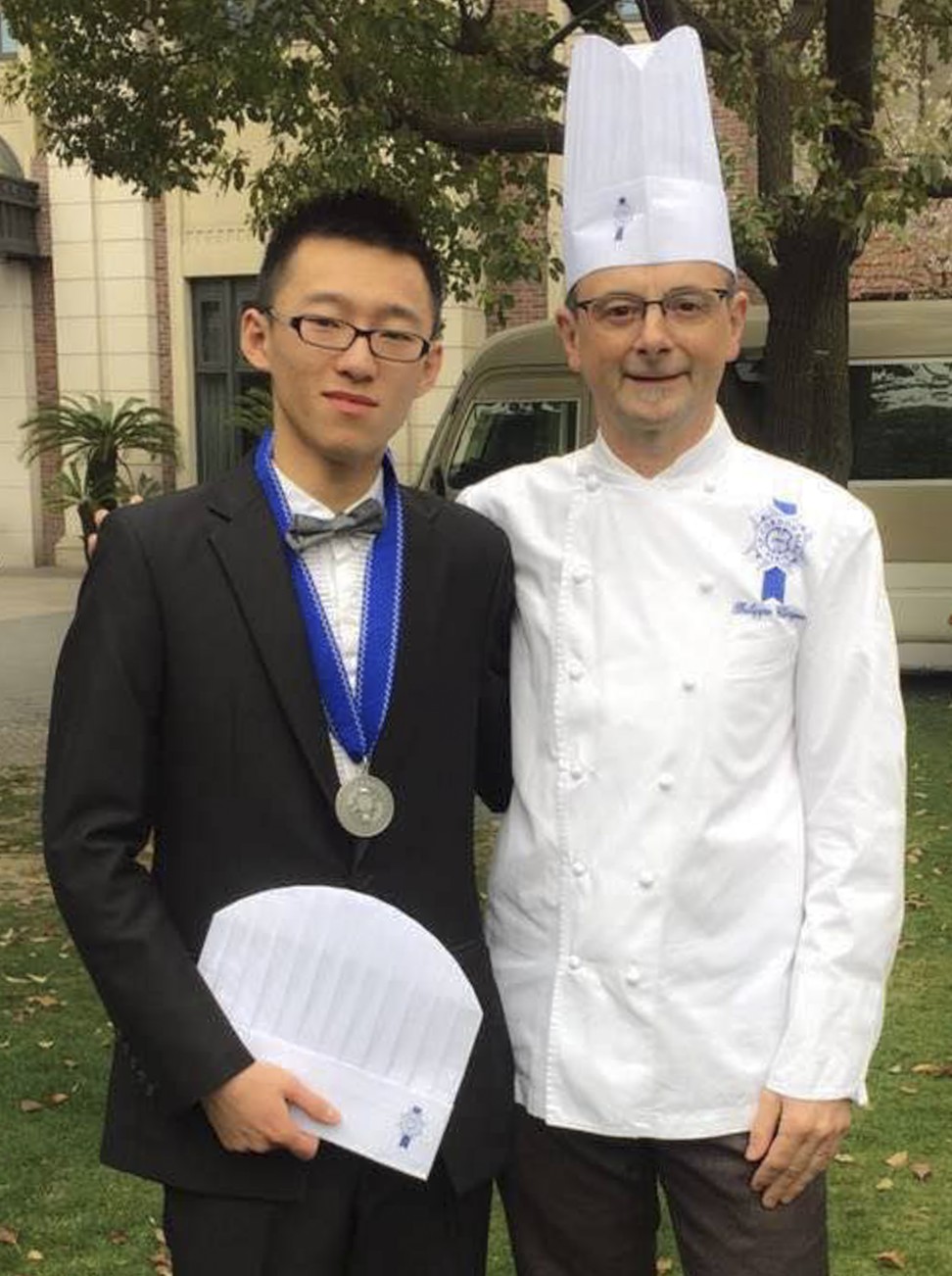 Luo (left) with one of his instructors at his graduation ceremony.