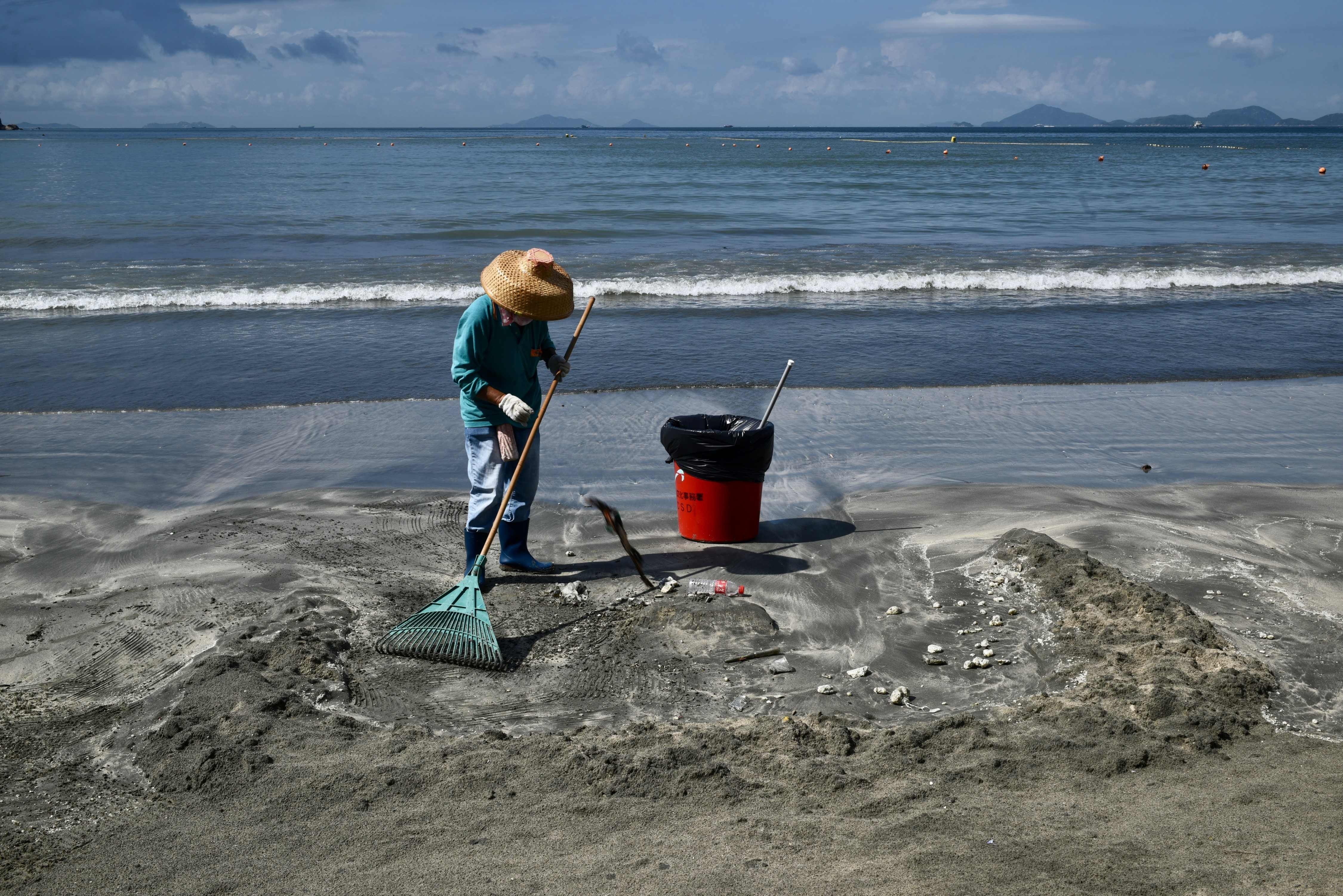 A cleaner at work on a Hong Kong beach. Under Hong Kong law, only employees engaged under a continuous contract are entitled to most benefits, including sick leave, annual leave, rest days, maternity and paternity leave and pay, end-of-year bonus, and the right to claim unreasonable dismissal. Photo: AFP
