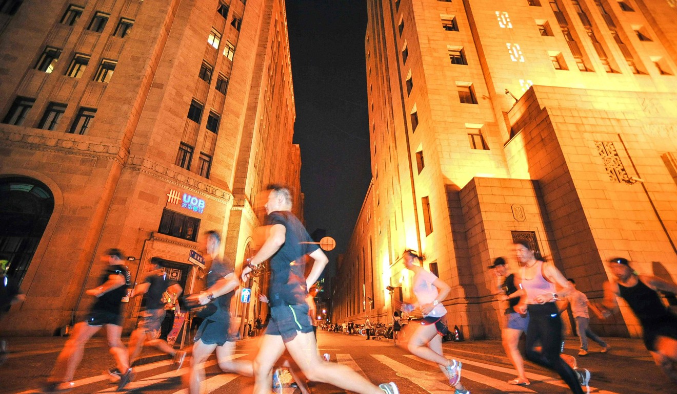A group of runners pass through the streets of Shanghai at night. Photo: AFP