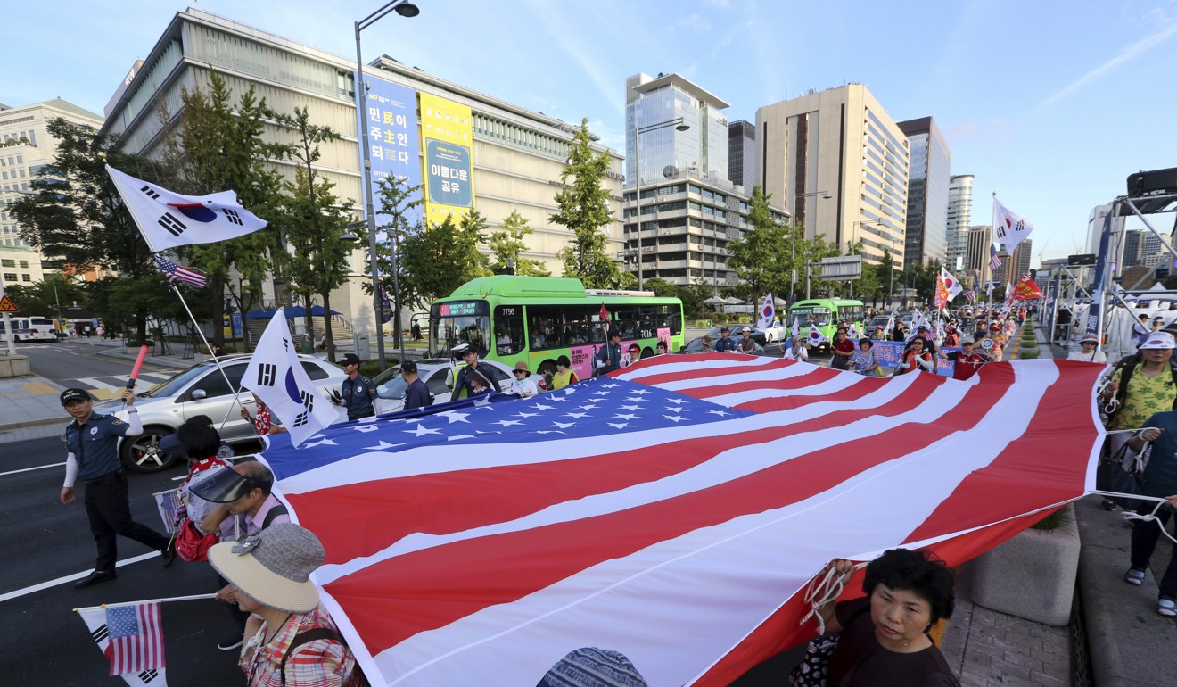 Supporters of former South Korean President Park Geun-hye march with a US flag during a rally urging the deployment of an advanced US missile defence system called Terminal High-Altitude Area Defence, or THAAD, in Seoul. Photo: AP