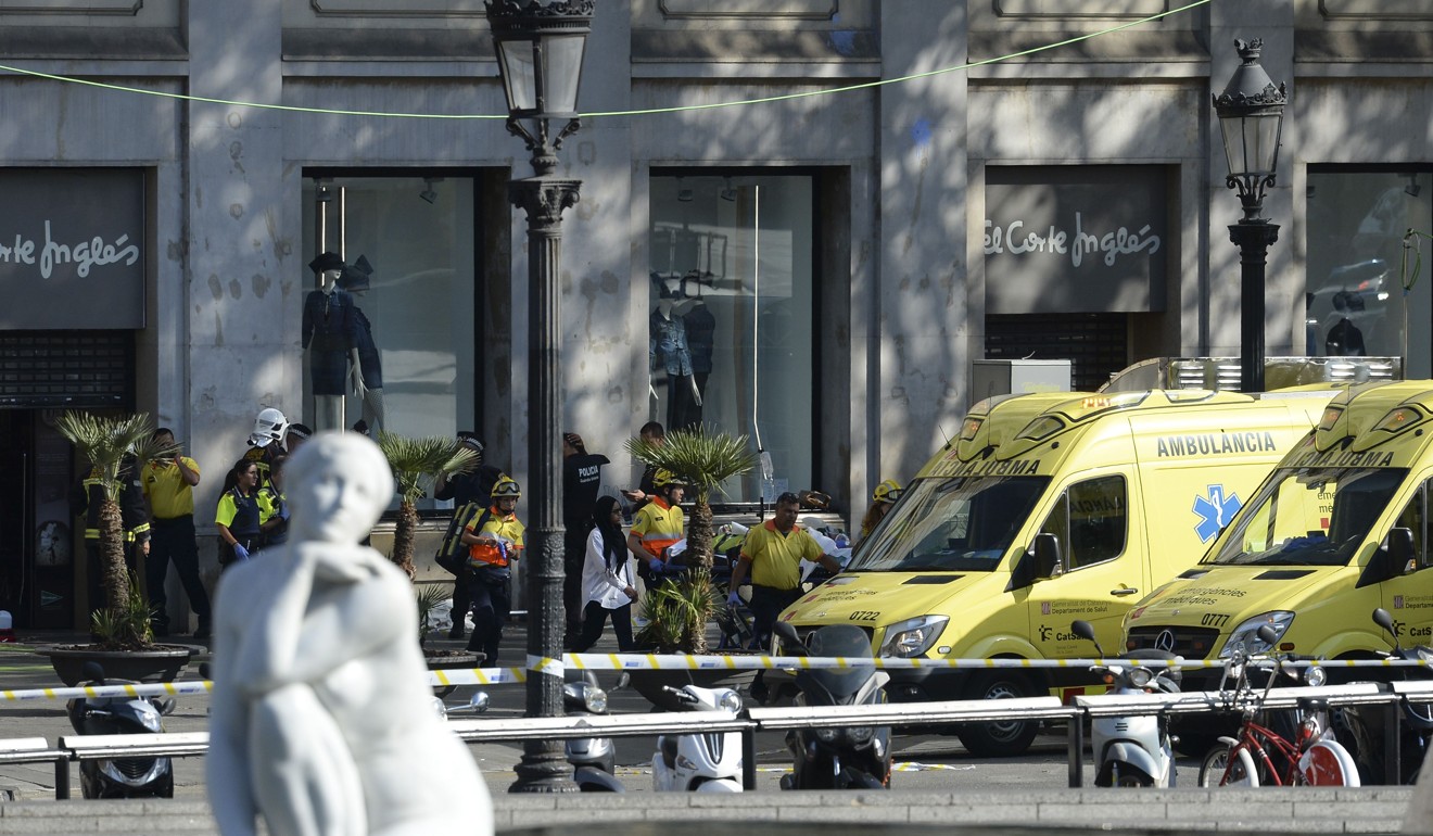 A person is stretched out of a mall by medical staff members in a cordoned off area after a van ploughed into the crowd, injuring several persons in Barcelona on August 17, 2017. Photo: AFP